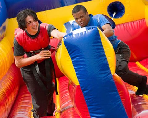 two students on a bouncy slide
