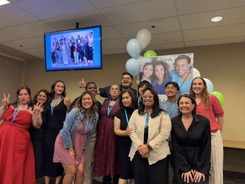Eleven new Certified Nursing Assistant (CNA) students smiling and posing together during their graduation ceremony,